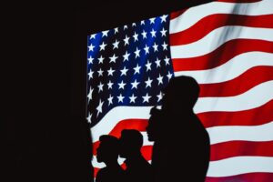 silhouettes in front of the American flag - Dan Moisand discusses if the 2020 presidential election will make the market crash